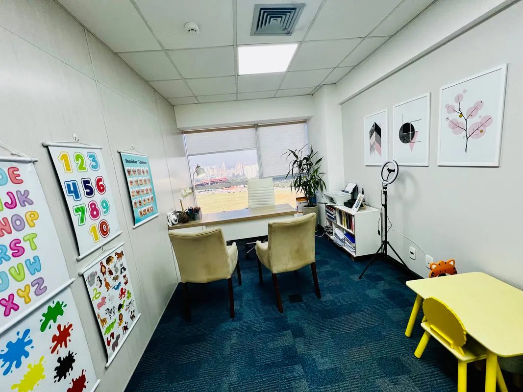 Sala de atendimento do consultório, com mesa, cadeiras e materiais de apoio